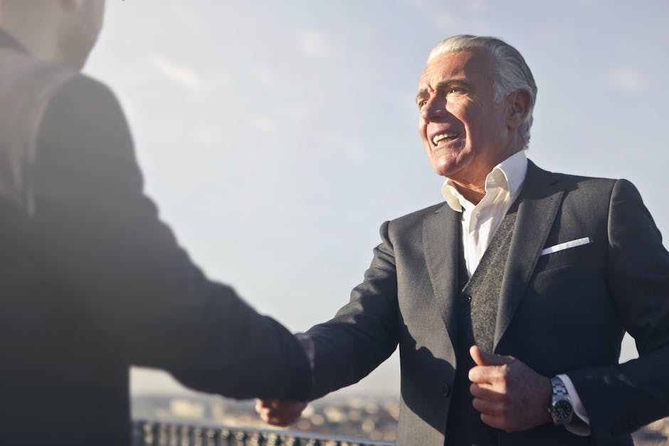 Image description: Illustration of two people shaking hands in agreement with a sunny weather background.