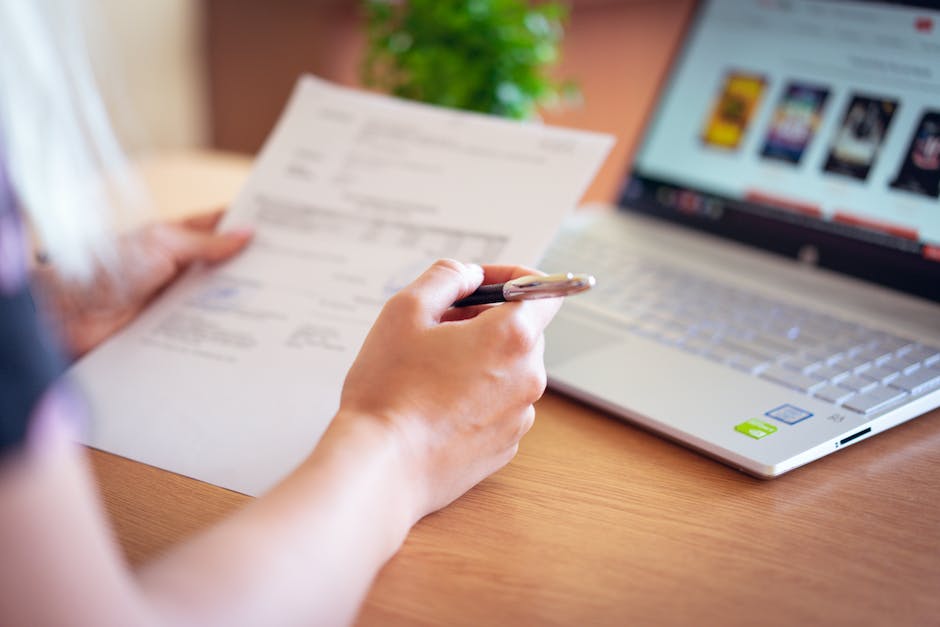 An image of a person holding a pen and paper, representing the act of writing and language usage.