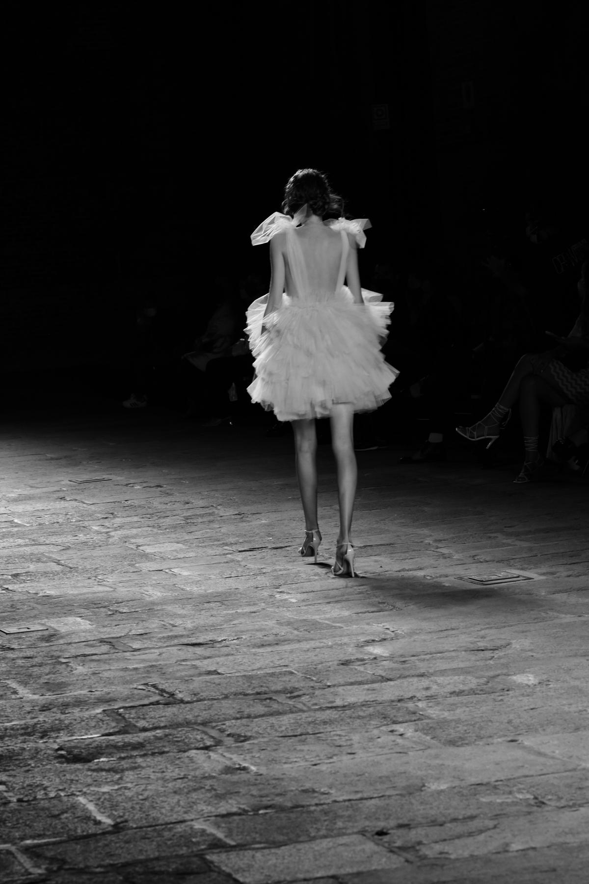 An image of a person confidently walking down a runway wearing a unique and empowering outfit.